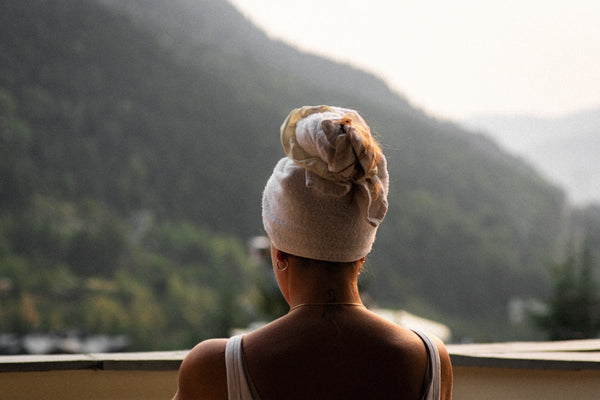 Woman with towel on head looking at mountains