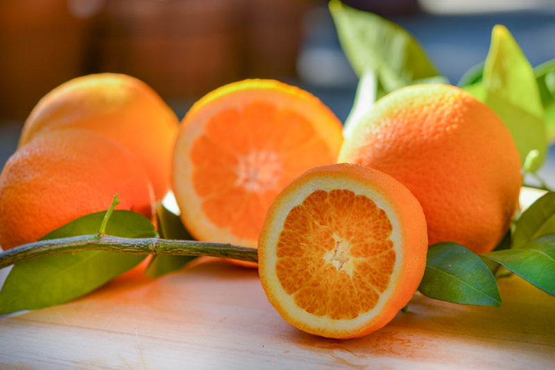 a group of oranges sitting on top of a wooden table