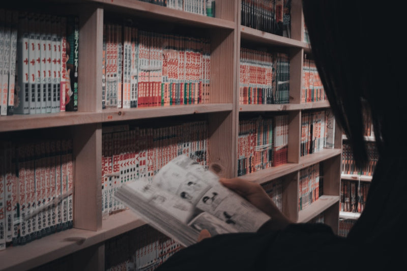 a person reading a newspaper in a library